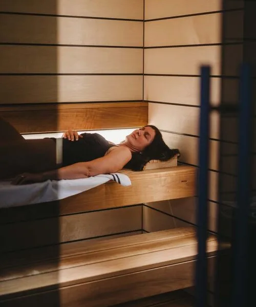 Woman lying inside Tylo Reflection Sauna GC WIDE