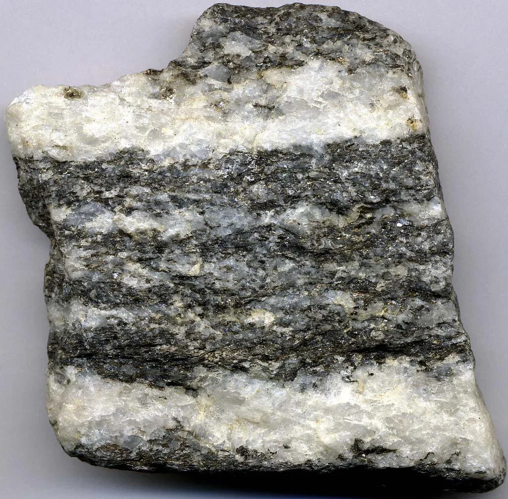 Gneiss is a metamorphic rock with characteristic bands resulting from an arrangement of mineral grains.